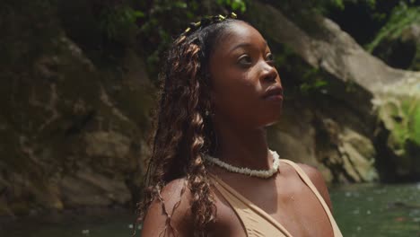 two girls in bikinis revel in the atmosphere of a tropical waterfall and river in the caribbean.
