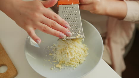 woman grating eggs for egg salad