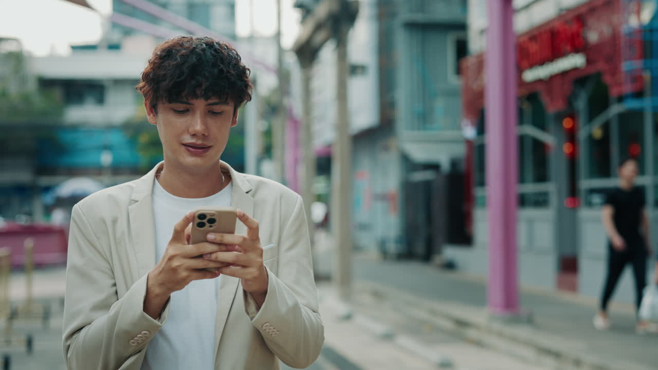 Man using smartphone on city street