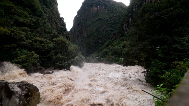 Urubamba River Flowing Rapidly Past During Rainy Season In Aguas Calientes At The Base Of Machu Picchu In Peru. Slow Motion Shot