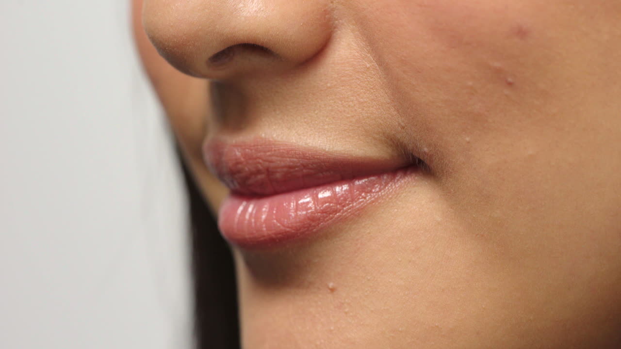 신경질을 주는 여드름을 가진 수줍어하는 여성의 입