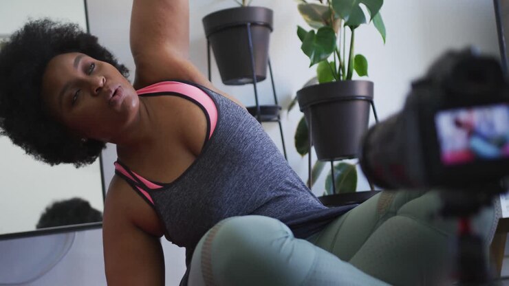 vlogger afroamericana de tamaño grande que graba un video sobre hacer ejercicio