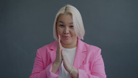 woman in pink blazer with applause gesture