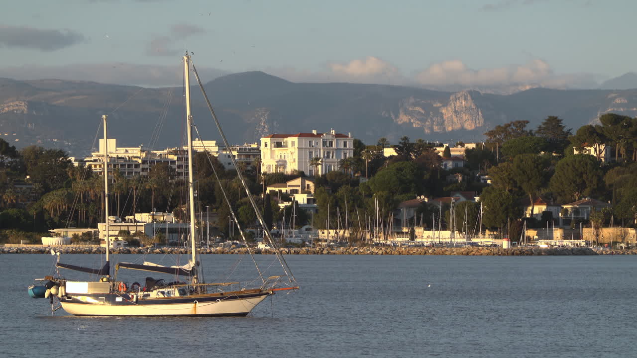 Antibes, Francia - 21 marzo 2025: Barca ormeggiata sul mare con la città sullo sfondo