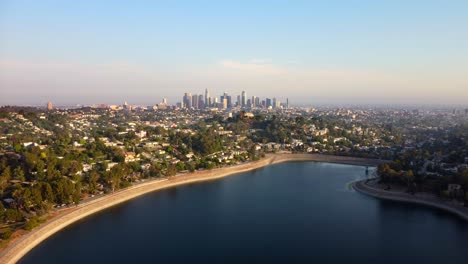 Drohnenaufnahme-Des-Silver-Lake-Reservoirs-Und-Der-Innenstadt-Von-Los-Angeles-In-Der-Ferne