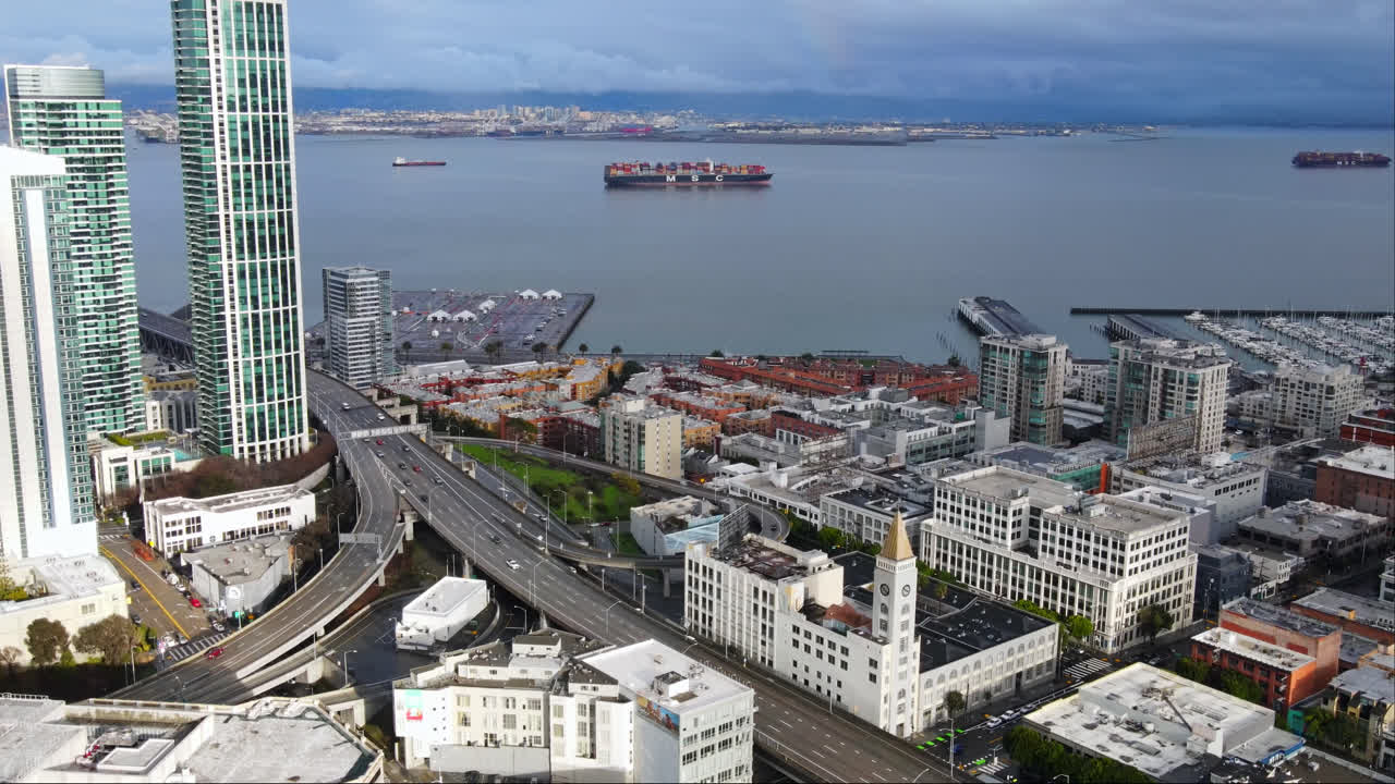 vista aérea cinematográfica de la autopista de south beach que conecta san francisco y oakland, el puerto de south beach con barcos de contenedores, california, estados unidos