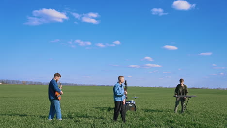 musical band playing on grass. group of young people playing instruments on field