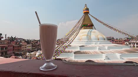 Mango-Lassi-drink-in-a-glass-in-front-of-the-huge-Stupa-in-Kathmandu