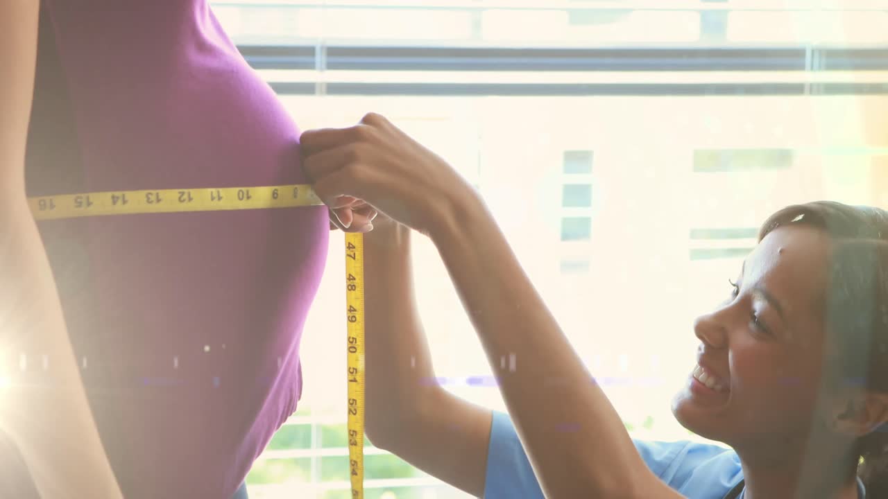 Spot of light against african american female medical worker measuring tummy of a pregnant woman