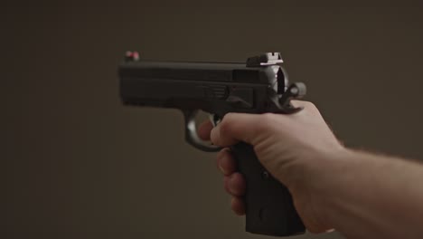 pulgar volteando hacia abajo el seguro de una pistola de 9 mm y disparando en seco