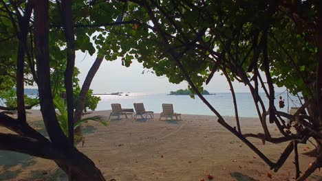 lockdown shot of of beach and deck chairs on seashore in maldives