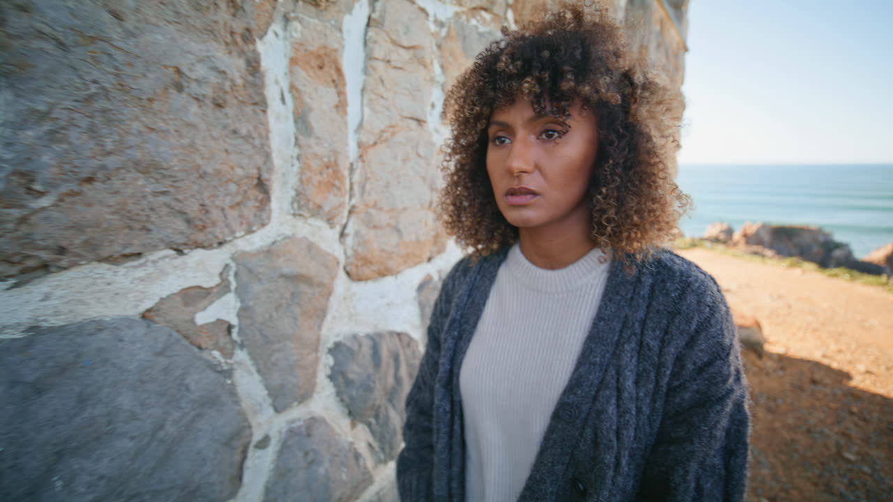 Frustrated model contemplating life near castle closeup. Curly woman thinking