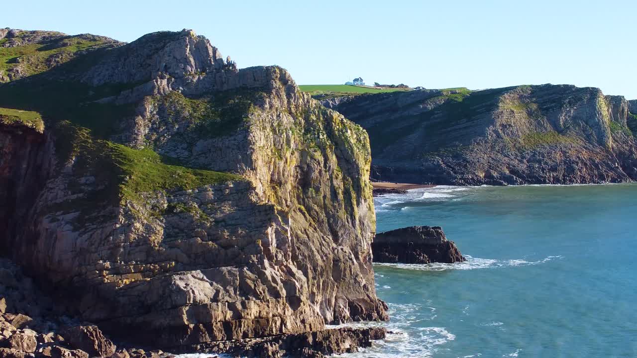 Layers of Coastal Cliffs from Aerial Perspective as Drone Rotates Around Dramatic Eroding Coastline with Calm Sea Below. Beautiful Gower Peninsula Scenic Tourist Holiday Destination