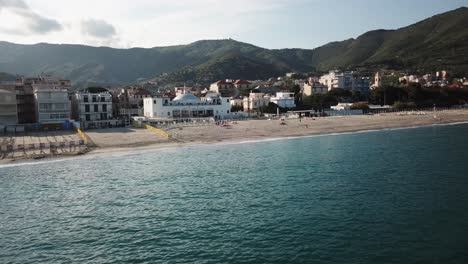 Vista-De-Drones-De-La-Tranquila-Superficie-Mediterránea-Cerca-De-La-Costa-Durante-Una-Puesta-De-Sol