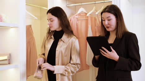 asian and caucasian woman in wedding dress shop