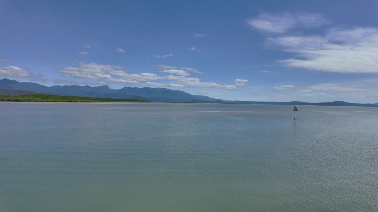 4K sweeping footage of a bay in North Queensland in Australia with beautiful mountains in the background