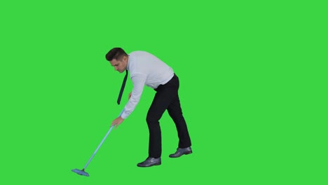 man with thumb up holding broom in formal clothes or business outfit after sweeping floor on a green screen, chroma key