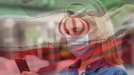 animation of flag of iran waving over caucasian woman wearing face mask