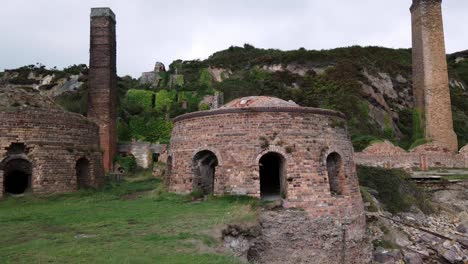 Walking-through-grassy-Porth-Wen-abandoned-brickwork-furnace-ruins,-Anglesey-industrial-site