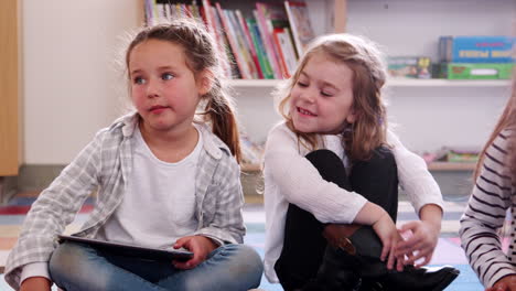 dos escolares de primaria usando una tableta en la clase