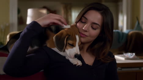 a young woman lovingly holds a beagle puppy on her shoulder