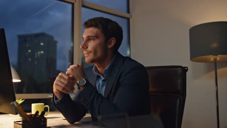 pensive employee working night in office. tired businessman checking hand watch
