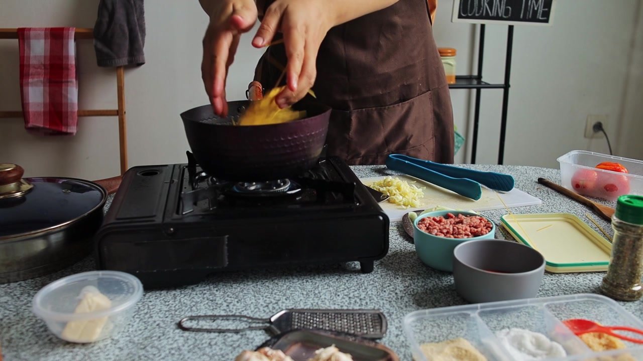 Cocinero casero sacando tomates hervidos de la olla y añadiendo espaguetis al agua hirviendo