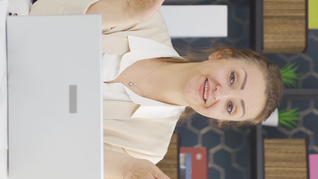 video vertical de una mujer de negocios aplaudiendo mientras mira a la cámara con orgullo y alegría.