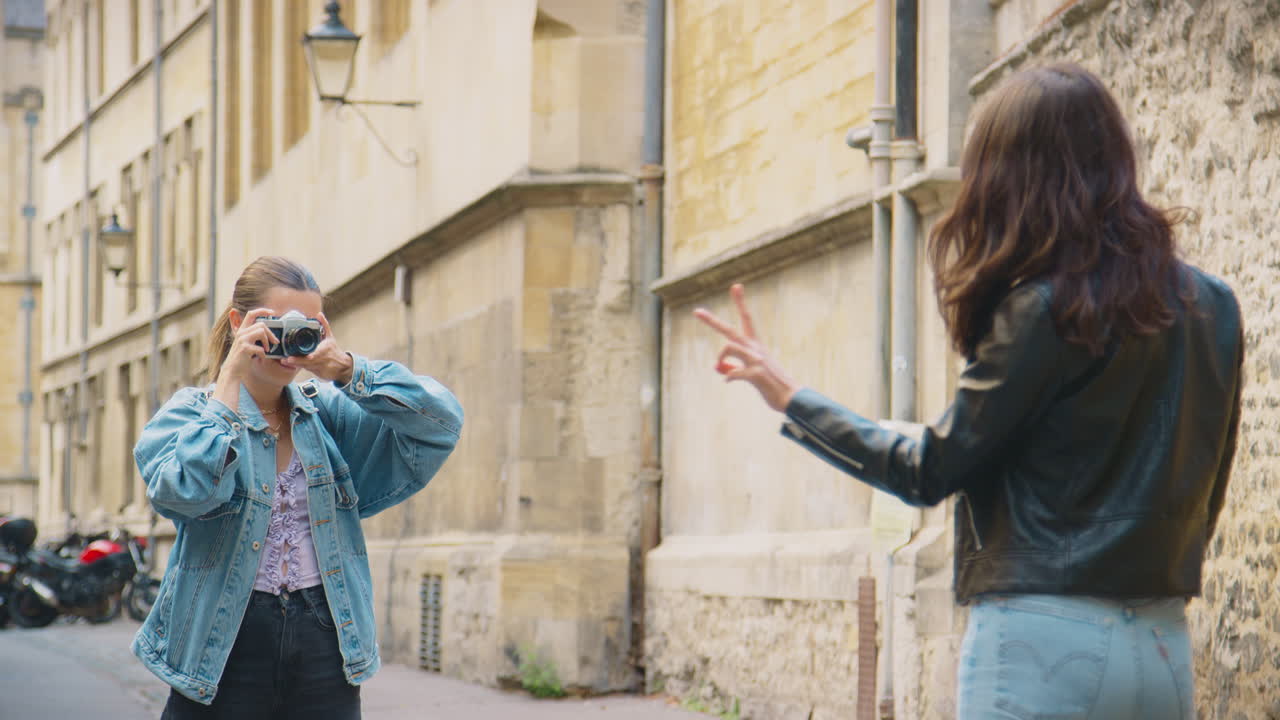 Same Sex Female Couple Taking Photos Of Each Other On Retro Digital Camera Around Oxford UK Together