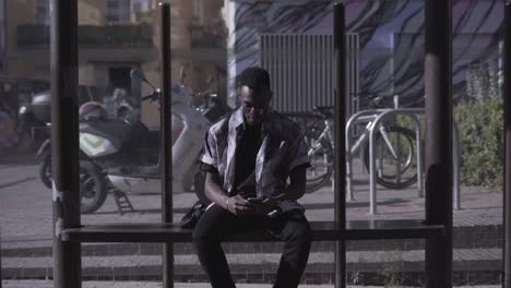 man using smartphone at bus stop