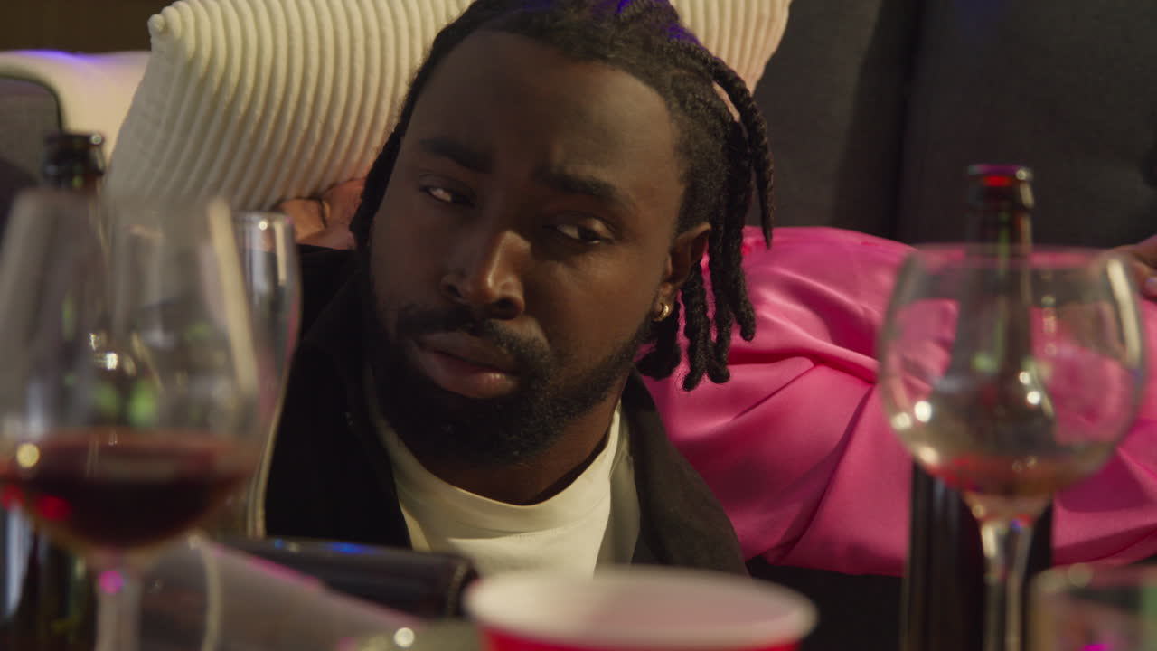 Close Up Of Couple Waking Up On Sofa After Drinking Alcohol At House Party Suffering With Hangover