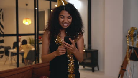 excited black woman using a phone at new year's eve party