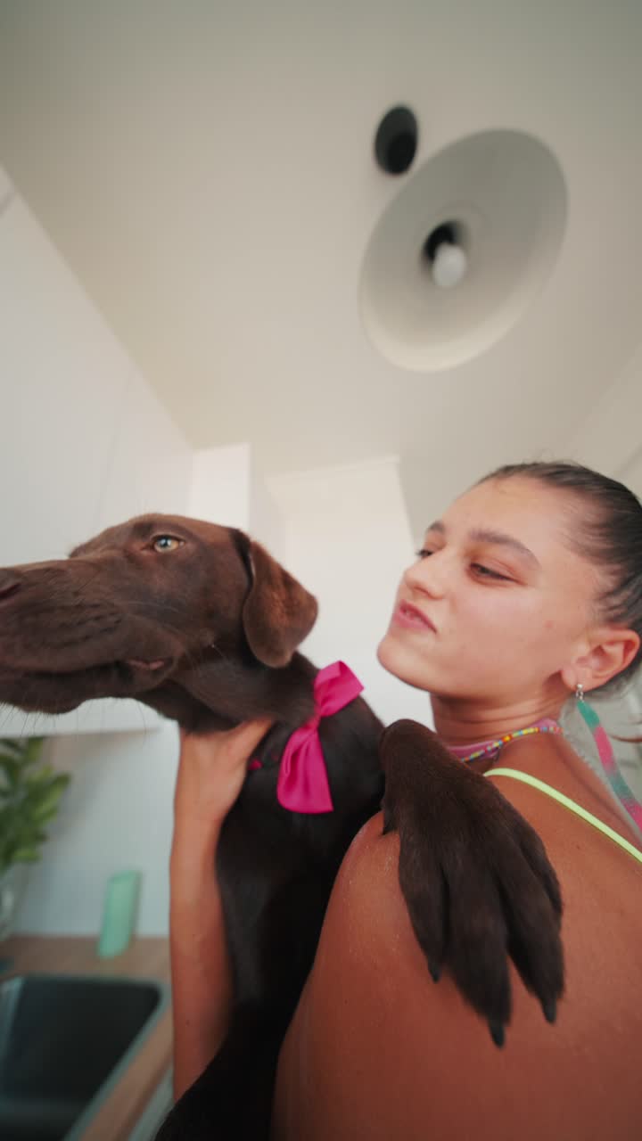 Woman holding her dog indoors