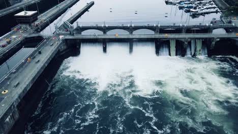 stationary aerial view of water cascading down the ballard locks on an overcast day in seattle, wa