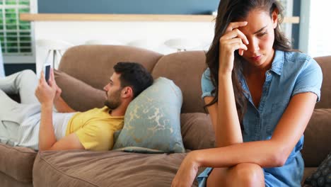 Couple-ignoring-each-other-in-living-room