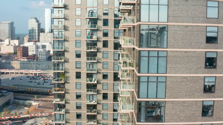 Ascensão aérea de um grande edifício de apartamentos urbano numa cidade moderna.