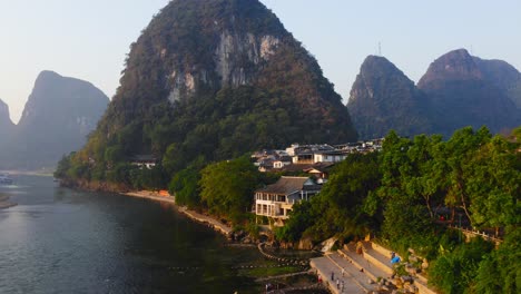 bâtiments en bord de mer au pied de la montagne karstique sur les rives de la rivière li, yangshuo, chine