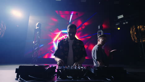 two djs performing on stage at a concert