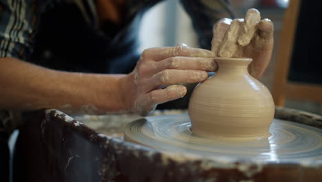 close-up view of a potter working on a pottery wheel