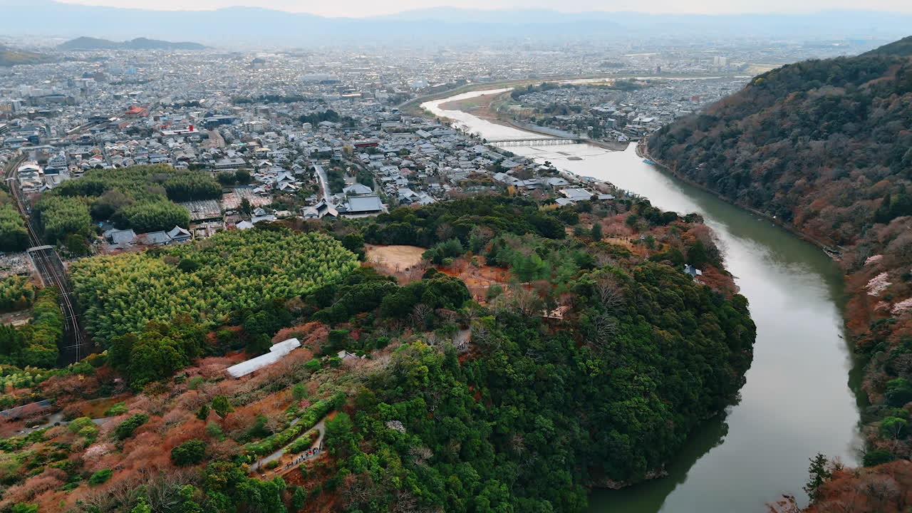 Scenic view of Kyoto, Japan. Drone footage above the Katsura river and mountains covered with woods.
