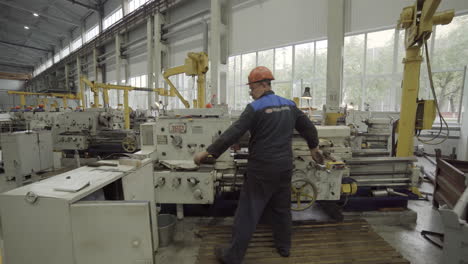 industrial workers operating metal lathes in a factory