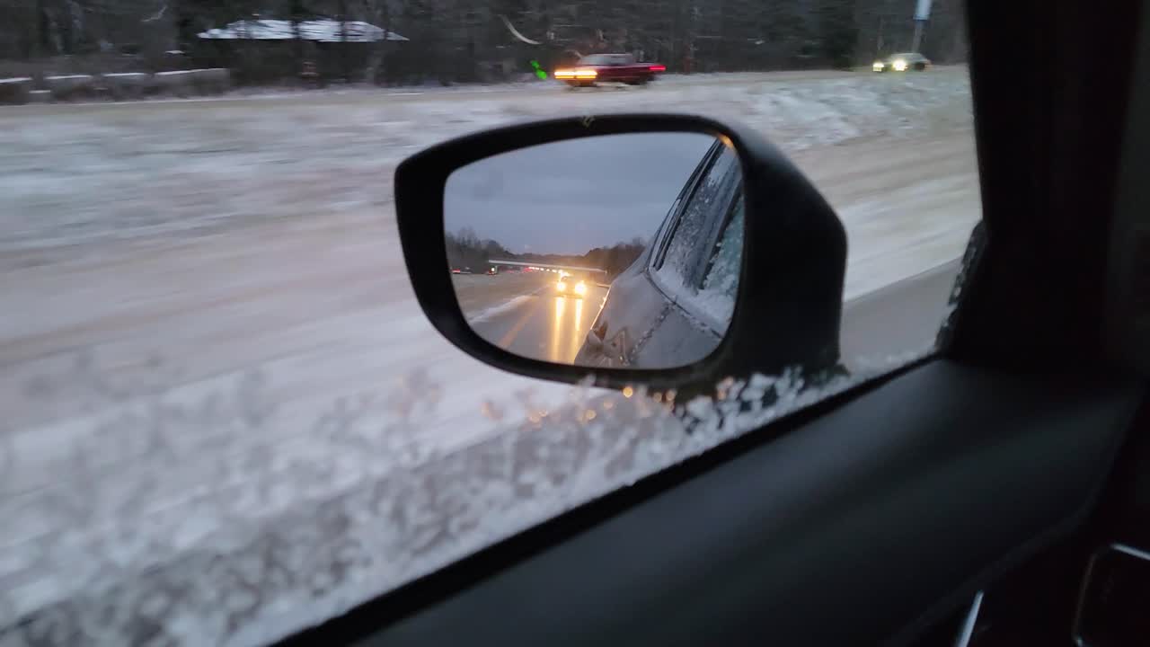 View of a Snowy Highway Through a Car's Side Mirror