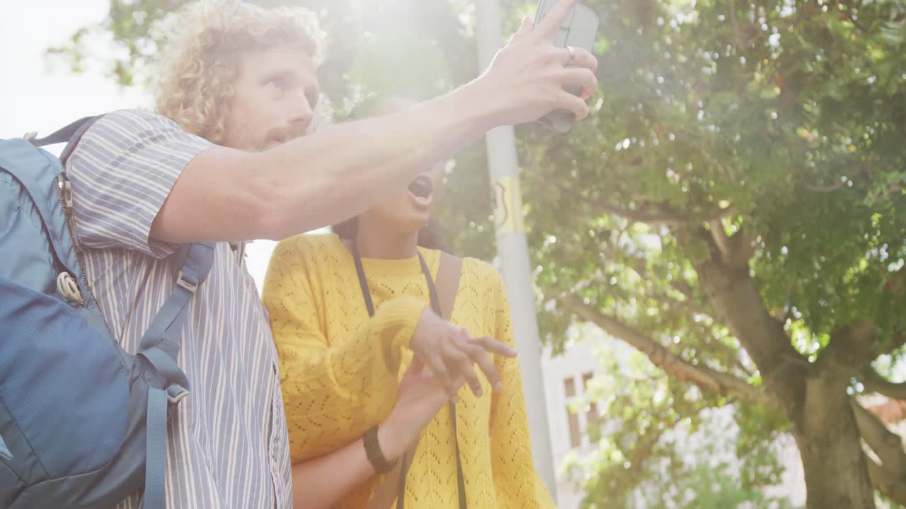 una pareja feliz con equipaje usando un teléfono inteligente en la ciudad.