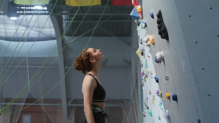 Donna che fa arrampicata in una palestra di arrampicata indoor