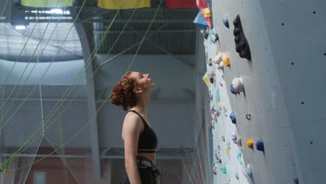 woman rock climbing at indoor climbing gym