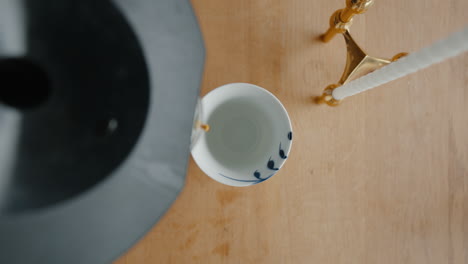 Pouring-fresh-coffee-into-a-traditional-cup-from-above