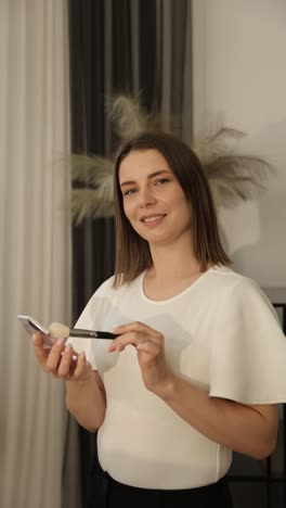 woman applying makeup with a brush and compact