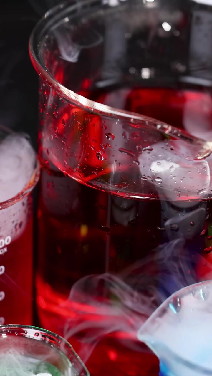 Becher con liquidi colorati e reazione con ghiaccio secco