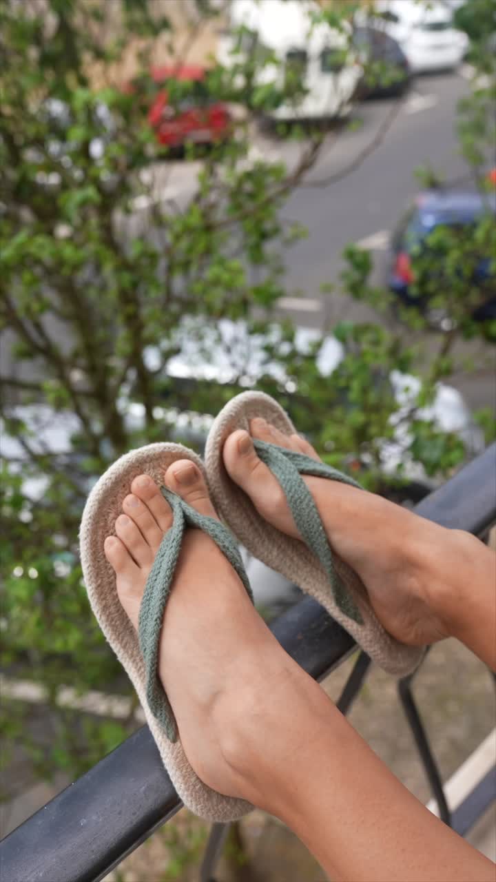 Person Relaxing on Balcony in Flip Flops