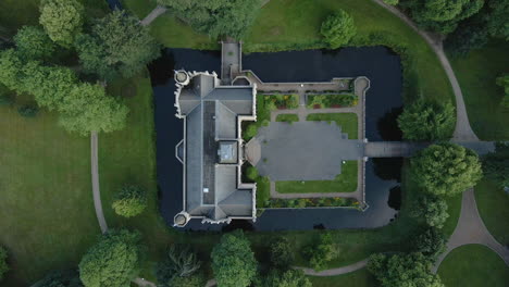 Top-down-View-Of-Schloss-Evenburg-Surrounded-By-Water-With-English-Garden-In-Leer,-North-Germany